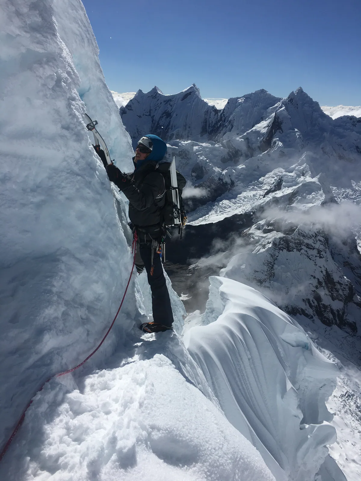 Un alpiniste progresse contre une paroi de glace en haute montagne