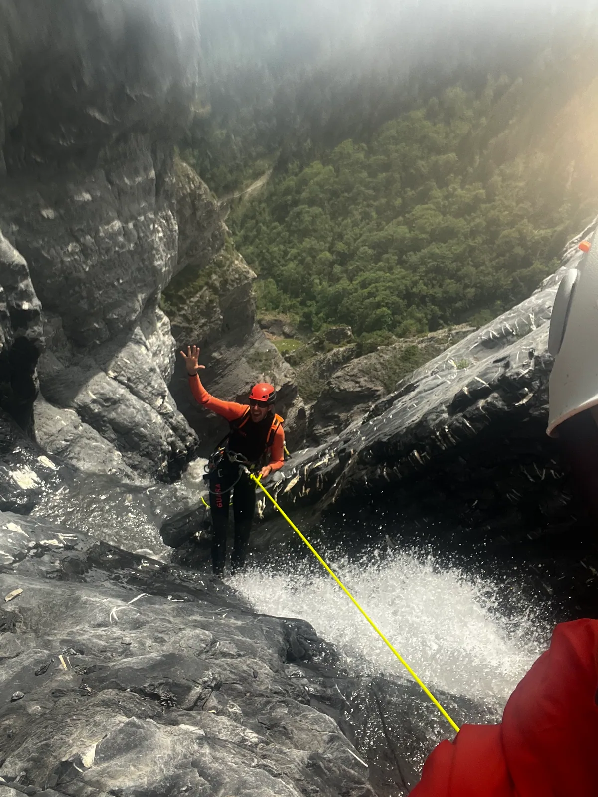Une descente en rappel dans un canyon, avec la corde visible au premier plan