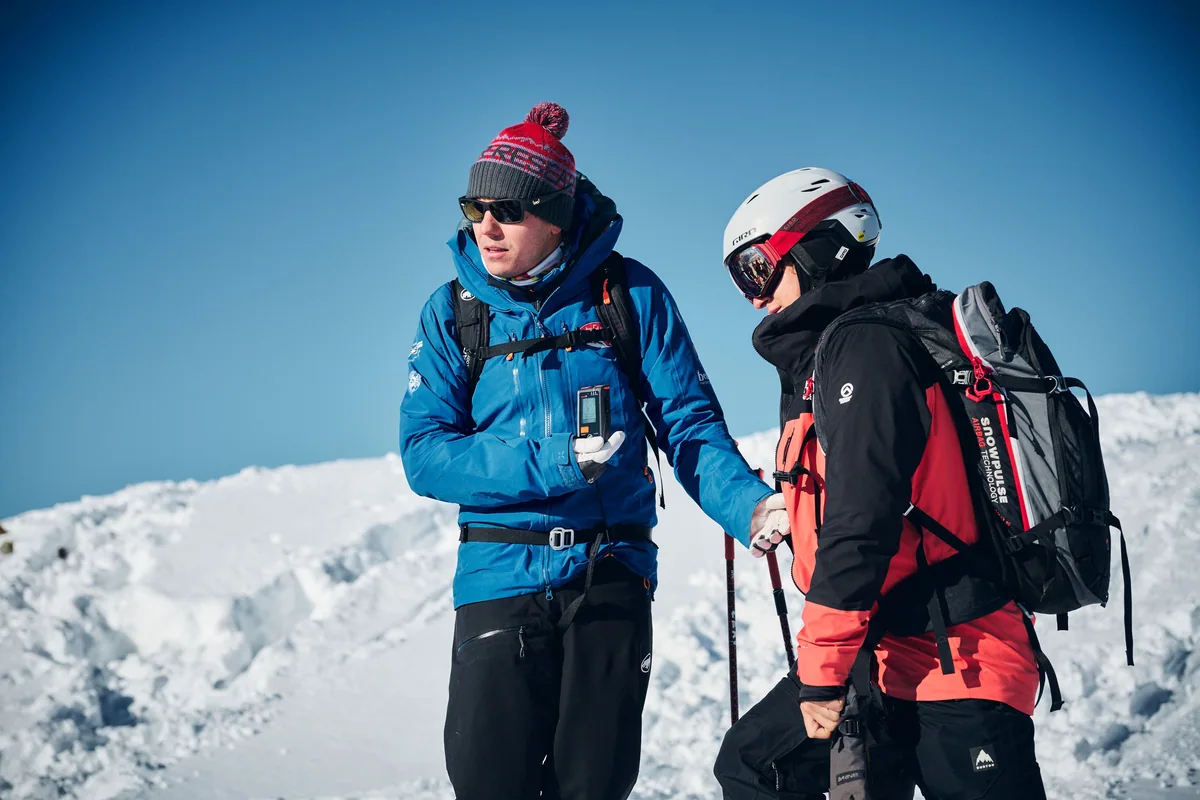 Explication de l’utilisation du détecteur de victimes d’avalanche avec un participant