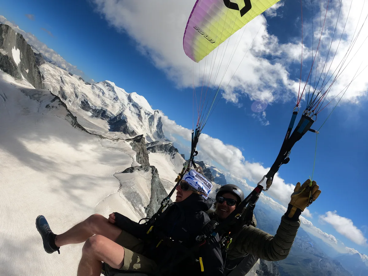 Vol en parapente biplace devant un glacier et de grandes parois alpines