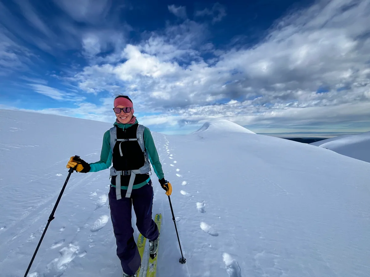 Un participant souriant monte à ski sur une pente enneigée